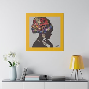 May include: A framed canvas art print featuring a silhouette of a woman wearing a colorful head wrap and jewelry. The artwork is set against a gray background within a yellow frame, creating a striking contrast. The woman's profile is in a side view.