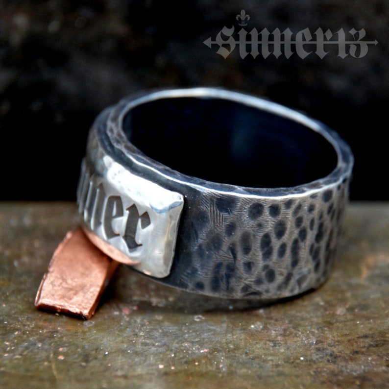 May include: A silver ring with a hammered finish and a rectangular silver plate with the word "Summer" engraved in black lettering.