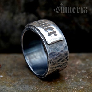 May include: A silver ring with a hammered finish and a rectangular silver plate with the word "Summer" engraved in a gothic font.
