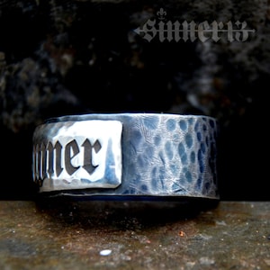 May include: A silver hammered metal band with the word "Summer" engraved in black lettering.