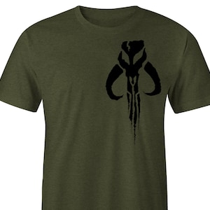 May include: A green t-shirt with a black Mandalorian symbol printed on the front.