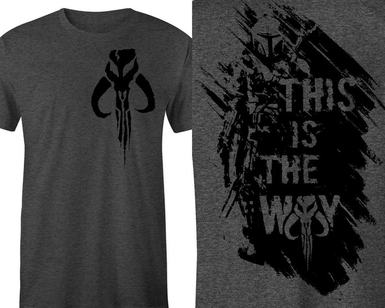 Puede incluir: Camiseta gris oscuro con un dise&ntilde;o de calavera mandaloriana negra en la parte delantera. La parte posterior de la camiseta tiene un gr&aacute;fico negro de una figura mandaloriana con el texto "THIS IS THE WAY".