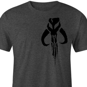 Puede incluir: Camiseta gris oscuro con un emblema negro de calavera mandaloriana. El emblema est&aacute; centrado en el pecho. La camiseta est&aacute; hecha de un material suave y c&oacute;modo.