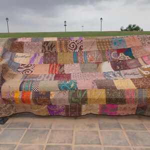 May include: A rectangular patchwork quilt featuring a variety of fabric squares in diverse colors, patterns, and textures. The quilt is stitched with visible running thread patterns throughout and displays the text "GaneshExpert" in two locations.