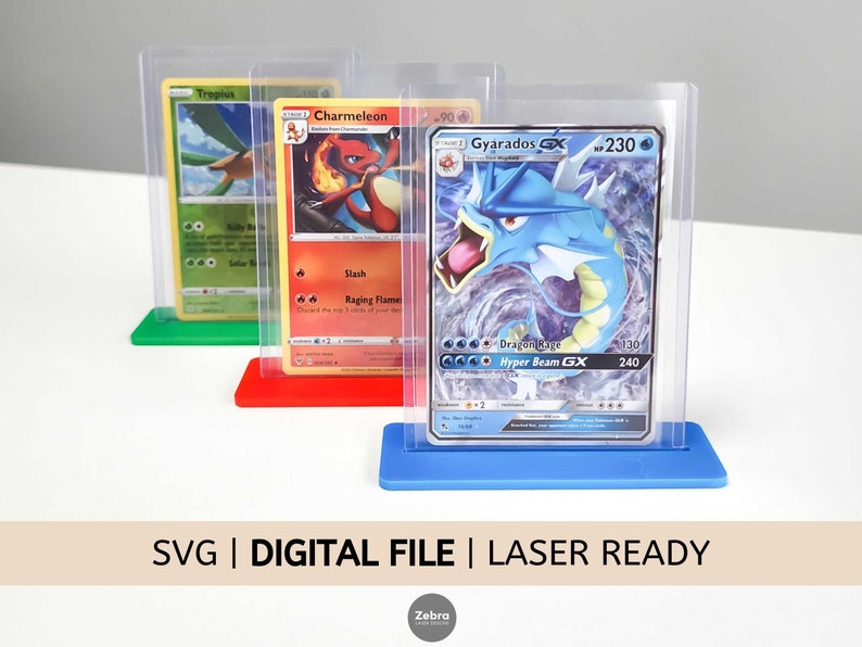 May include: Three clear plastic card holders with different colored bases. The bases are green, red, and blue. Each holder has a Pokemon trading card inside. The cards are Trepius, Charmeleon, and Gyarados GX. The text "SVG | DIGITAL FILE | LASER READY" is at the bottom of the image.