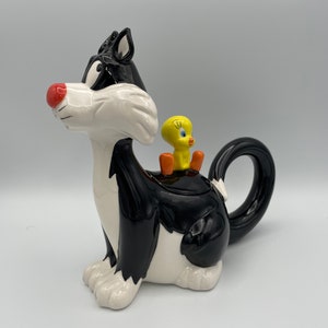 Looney Tunes Sylvester Cat y Tweety Bird en la tetera sentada de espaldas