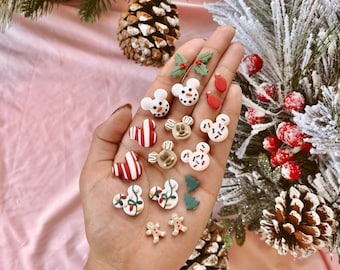 May include: A collection of Christmas-themed polymer clay earrings. The earrings feature various designs, including a snowman, a gingerbread man, a Christmas tree, and a candy cane. The earrings are all in a festive color palette of red, green, and white.