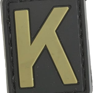 May include: A black and tan velcro patch with the letter "K" in a tan color.