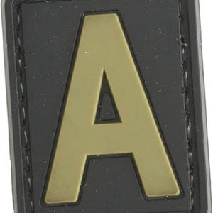 May include: A black and tan velcro patch with the letter "A" in a tan color.