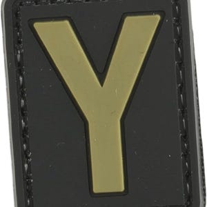 May include: A black patch with a gold-colored letter Y in the center. The patch has a stitched border.