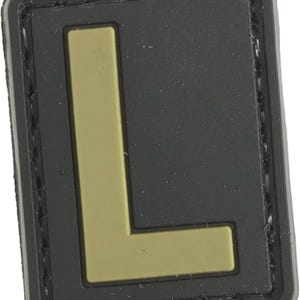 May include: Black and tan velcro patch with a large tan letter L.