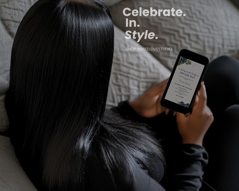 May include: A person holding a smartphone with a digital invitation for a baby shower. The invitation features a watercolor design with blueberries and the text "A Baby Shower Party is On The Way".