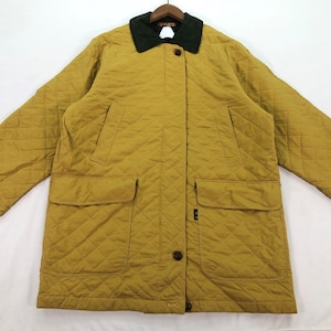 May include: A quilted jacket with a dark green corduroy collar and a button closure. The jacket is a mustard yellow color and has two large pockets on the front.