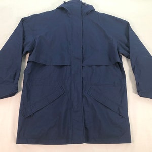 May include: A navy blue hooded jacket with a zipper closure and two front pockets. The jacket has a long sleeve design and a relaxed fit.