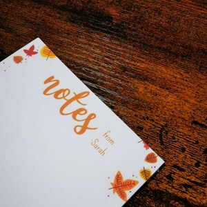 May include: White notepad with a fall theme border. The notepad has the word "notes" written in orange cursive and the text "from Sarah" below it.