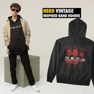 Puede incluir: Sudadera con capucha negra con un gráfico de banda en la espalda. El gráfico presenta a tres personas con la palabra "NERD" y el texto "NO ONE EVER REALLY DIES".