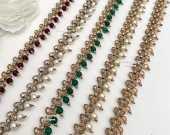 Puede incluir: Cinco tiras decorativas con engastes metálicos dorados en forma de hoja con cristales transparentes y cuentas redondas alternas en granate, blanco, verde y melocotón claro, con el texto IndoExquisite Designs visible.