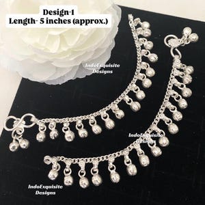 Könnte beinhalten: Silberne Fußkettchen mit baumelnden Glockenanhängern. Die Fußkettchen sind etwa 12,7 cm lang. Der Text "Design-1" und "Length- 5 inches (approx.)" ist sichtbar. Der Markenname "IndoExquisite Designs" ist ebenfalls sichtbar.