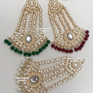May include: Three gold-tone headpieces with pearl and rhinestone embellishments. The headpieces have three strands of pearls and rhinestones. The headpieces are decorated with green, red, and white beads.