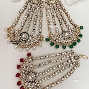 May include: A set of three gold-tone hair chains with pearl and gemstone accents. The chains feature a crescent-shaped design with multiple strands of pearls and gemstones. The chains are available in three colors: green, red, and white.