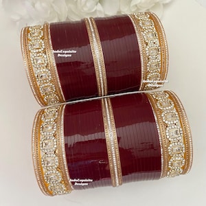 Può includere: Un set di braccialetti marroni e dorati con decorazioni in strass bianchi. I braccialetti sono impilati uno sopra l'altro e presentano un design decorativo. Il testo "IndoExquisite Designs" è visibile sui braccialetti.