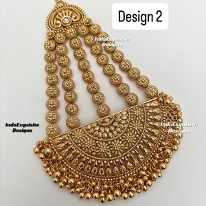 May include: Gold-toned headpiece with intricate floral and circular designs. The headpiece features multiple strands of small, round embellishments and a half-moon shaped central piece. The text "Design 2" is visible.