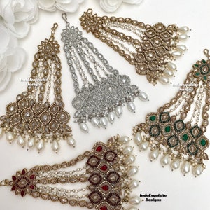 May include: Four gold-tone hair chains with pearl accents. Each chain features a different colored stone: red, green, white, and gold. The chains are arranged in a semi-circle on a white background. IndoExquisite Designs is printed on the bottom right corner.