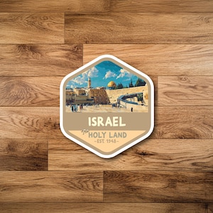 May include: A sticker with a hexagonal shape featuring a scenic view of Jerusalem, Israel. The image includes a golden-domed structure, a stone wall, and a blue sky with clouds. The sticker has the text "ISRAEL The HOLY LAND - EST. 1948."