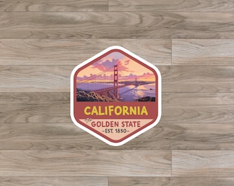 May include: A red and white sticker with a hexagonal shape features a scenic view of the Golden Gate Bridge in San Francisco, California. The sticker reads "The Golden State - Est. 1850 - California".