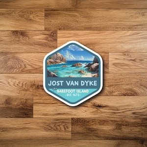 May include: A sticker with a scenic image of Jost Van Dyke, The Barefoot Island, featuring turquoise water, rocks, and a blue sky. The sticker has a white border and the text "JOST VAN DYKE" and "The Barefoot Island - EST 1672-".