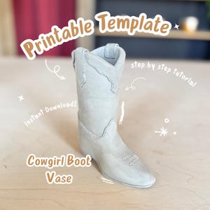 Könnte beinhalten: Eine hellgraue Cowgirl-Stiefel-Vase. Die Vase ist eine druckbare Vorlage und ein sofortiger Download. Der Text auf dem Bild lautet "Druckbare Vorlage", "Sofort-Download!", "Cowgirl-Stiefel-Vase" und "Schritt-für-Schritt-Anleitung".