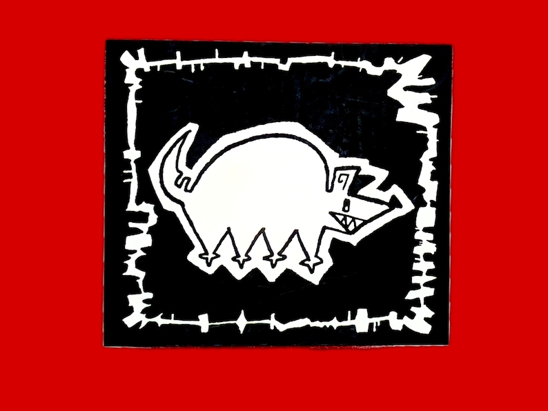 以下が含まれることがあります： 黒と白の漫画の動物のイラスト。ギザギザの口と4本の足が、黒の背景に白い枠の中に描かれている。