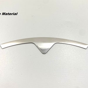 K&ouml;nnte beinhalten: Ein silberfarbenes Metallkernmaterial in Form eines gebogenen Bogens mit einer spitzen Mitte.