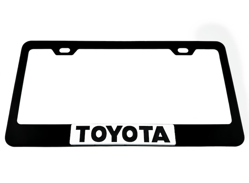 Pu&ograve; includere: Cornice per targa nera con logo "TOYOTA" argentato.