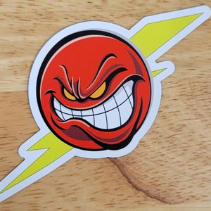May include: A red cartoon face with a menacing grin and yellow eyes, set against a yellow lightning bolt.