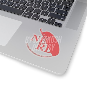 May include: A red and white sticker with the text "BY KUSH ORISY" and the words "GG GOOD GAME, GG. GOOD GAME."  The sticker is on a silver laptop.