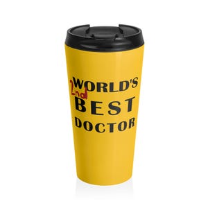 以下が含まれることがあります： 黒い蓋が付いた黄色のトラベルマグに「World's 2nd Best Doctor」の文字が印刷されています。