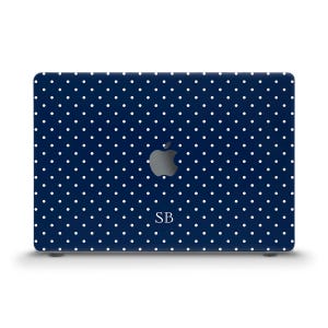 May include: A navy blue laptop case with a white polka dot pattern. The case features the Apple logo and the initials "SB" in white. The case is designed to fit a laptop.