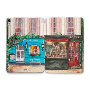 May include: A watercolor painting of two storefronts on a street. The storefront on the left is a cafe called "Coffee & Cake" with a blue facade and a white bench. The storefront on the right is a bookstore called "Books" with a red door and a sign that says "Library".