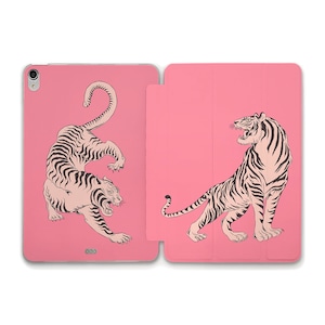 Puede incluir: Una funda rosa para iPad con una ilustración de tigre en blanco y negro en la parte delantera y trasera. El tigre de la parte delantera está en posición de cuclillas, mientras que el tigre de la parte trasera está de pie.