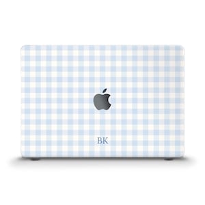 May include: A laptop with a light blue and white gingham pattern. The Apple logo is centered, with the initials "BK" below it. The laptop is a light color and has a clean, modern design.
