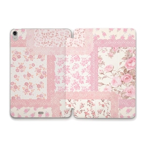 May include: A floral patterned tablet case with a patchwork design. The case features various pink floral patterns, including roses, and lace accents on a white background. The case is open, revealing the interior.