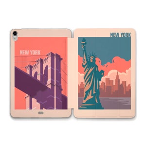 May include: A pink and beige tablet case with a split design. The left side features a vintage illustration of the Brooklyn Bridge with the text "NEW YORK". The right side features a vintage illustration of the Statue of Liberty with the text "NEW YORK" above the image.