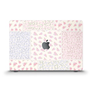 Peut inclure: Une peau d'ordinateur portable blanche avec un motif patchwork composé de motifs floraux roses et violets. Le logo Apple est visible au centre.