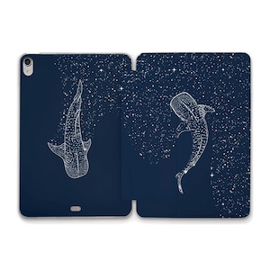 May include: A navy blue tablet case featuring a white illustration of a whale shark. The design includes a starry night sky background. The case is open, displaying the interior and exterior design.