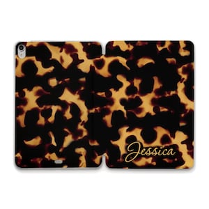 May include: A tortoiseshell patterned phone case with the name "Jessica" written in gold script.
