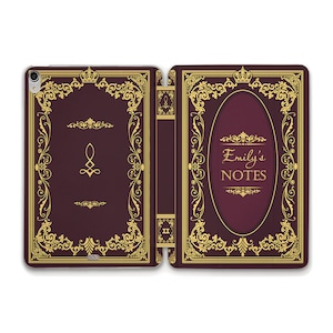 Może przedstawiać: Burgundowe etui na iPada z ozdobnym wzorem w kolorze złotym. Etui ma złotą koronę i napis "Emily's NOTES" z przodu.