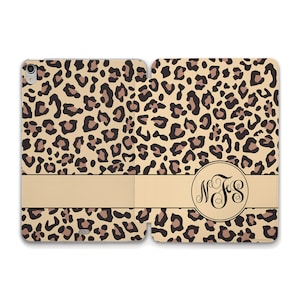 May include: A beige and brown leopard print iPad case with a beige band and a circle monogram with the initials "MFS" in black.