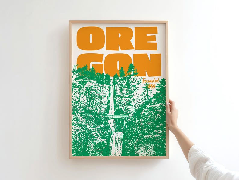 May include: A framed art print featuring the word "OREGON" in orange block letters above a green and white illustration of a waterfall and forest. The text "Founded 1859" is also present.