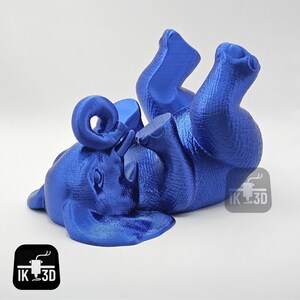 May include: A blue 3D printed elephant figurine with its trunk curled up. The elephant is lying on its side with its legs in the air.